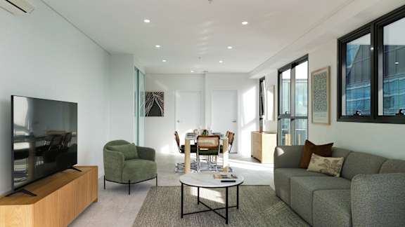 A modern living room with a flat screen TV and comfortable seating.