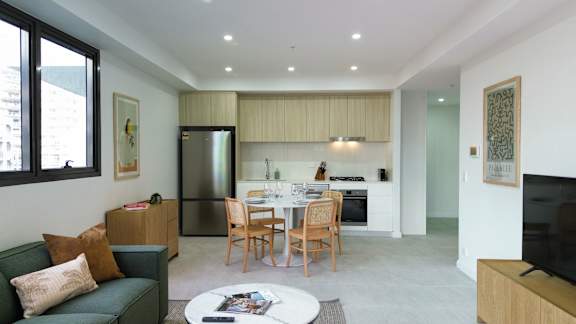 A modern living room with a green couch and a coffee table.