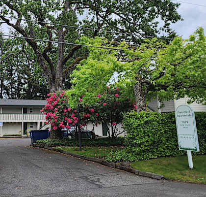 a building with a sign in front of it and some trees