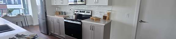 A kitchen with white cabinets and a stove top oven.