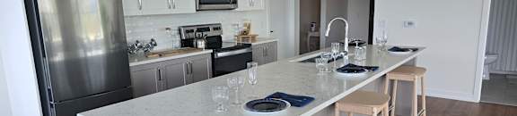 A kitchen with a white island and stools.