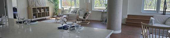 A kitchen with a marble countertop and a dining area with a wooden table and chairs.