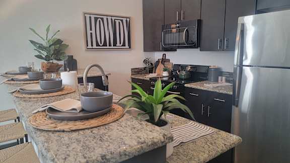 A kitchen with a granite countertop and a fridge.