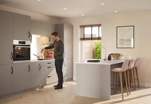 A man is standing in a kitchen with a white counter and a window.