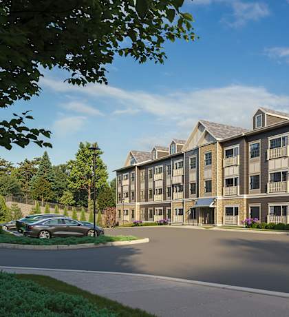 A modern apartment complex with a car parked in front.