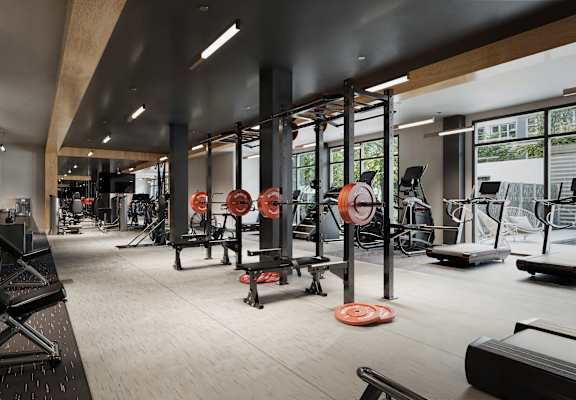A gym with a variety of equipment including weightlifting machines and benches.