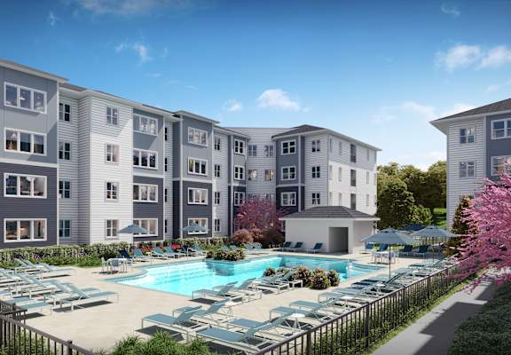 A large apartment complex with a pool in the foreground.