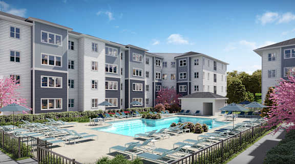 A large apartment complex with a pool in the foreground.