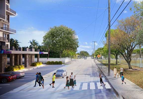 A street scene with people crossing the road.