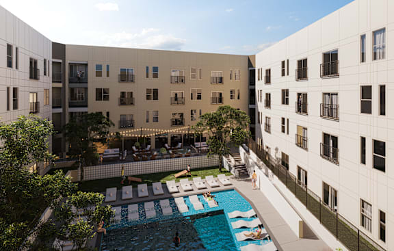 A swimming pool is surrounded by lounge chairs and umbrellas.