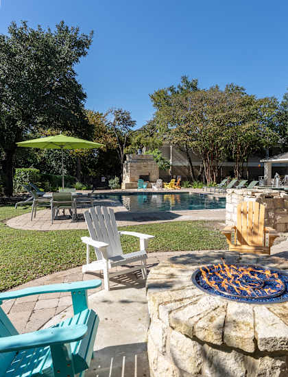 a backyard with a pool and patio with chairs and a fire pit at Northland at the Arboretum, Austin, 78759