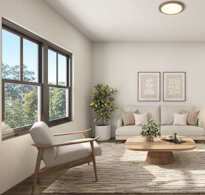 A living room with a sofa, a coffee table, and a potted plant.
