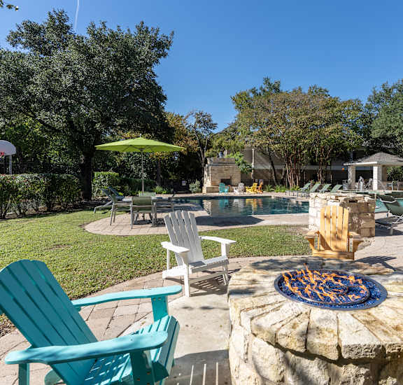 a backyard with a pool and patio with chairs and a fire pit at Northland at the Arboretum, Austin, 78759