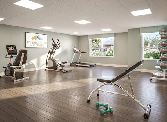 A gym with a variety of equipment including a treadmill, weights, and a bench press. at Evergreen Heights Apartments, Toledo, 43614