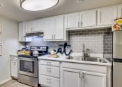 Thumbnail 4 of 15 - a kitchen with white cabinets and stainless steel appliances and a sink at Summers Point Apartments, Glendale, 85301