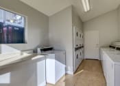 Thumbnail 11 of 15 - a laundry room with washes and dryers and a window at Summers Point Apartments, Glendale