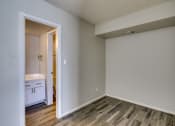 Thumbnail 7 of 15 - an empty room with wood flooring and a door to a bathroom at Summers Point Apartments, Glendale, 85301