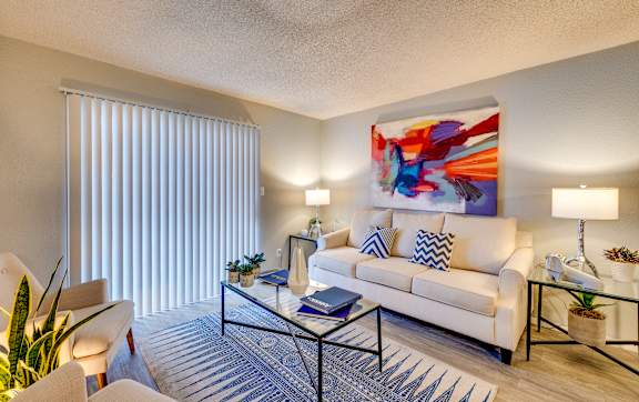 a living room with a white couch and a coffee table at Summers Point Apartments, Glendale