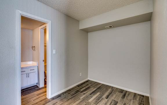 an empty room with wood flooring and a door to a bathroom at Summers Point Apartments, Glendale, 85301