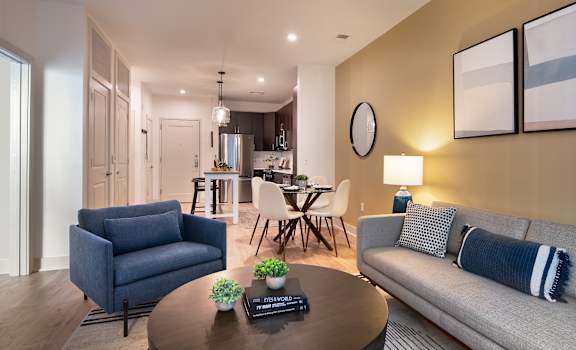 A modern living room with a grey sofa, a blue armchair, and a coffee table.