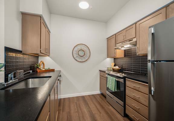 A kitchen with a black countertop and wooden cabinets.