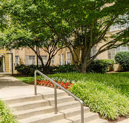 A building entrance with steps and a metal railing.