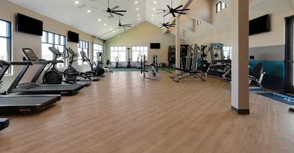 A spacious gym with treadmills, exercise bikes, and other equipment.