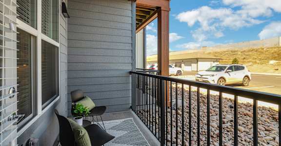 A balcony with a chair and a potted plant.