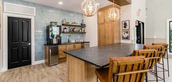a kitchen with a large island and a bar with chairs