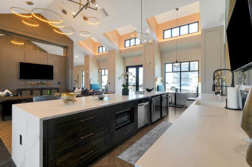a kitchen with a large center island with a breakfast bar and a living room in the background  at Upland Flats, Colorado Springs, Colorado