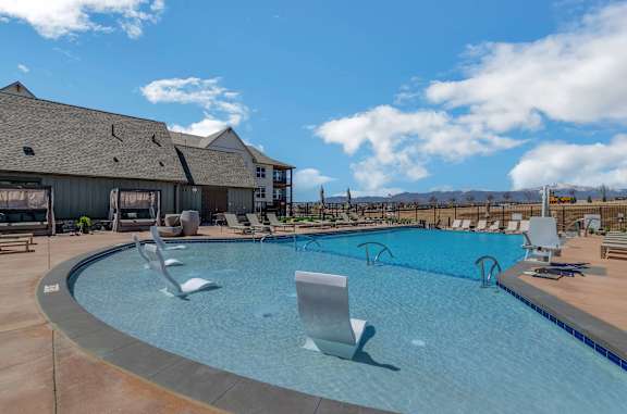 a large swimming pool with lounge chairs and a building in the background  at Upland Flats, Colorado Springs, Colorado
