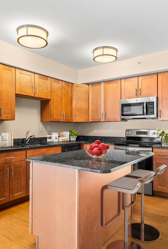 A kitchen with wooden cabinets and a black counter top.