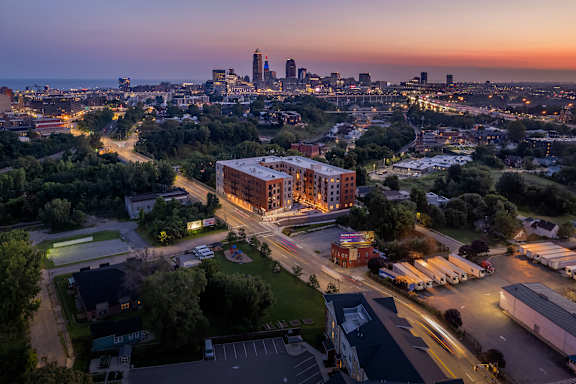 A cityscape at dusk with a prominent building in the foreground.