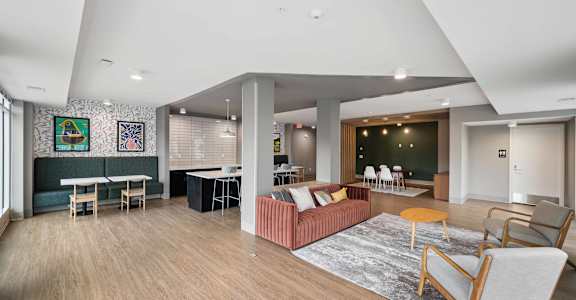 A living room with a couch, chairs, and a rug.