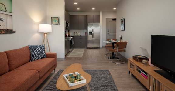 A living room with a couch, a coffee table, and a television at The Park Apartments, Cleveland 44113