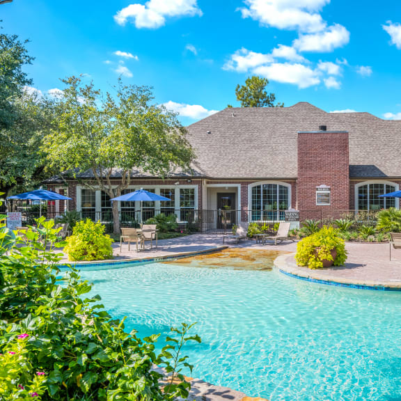 a large swimming pool with a house in the background
