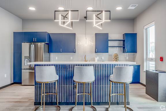 A kitchen with blue cabinets and a white counter.