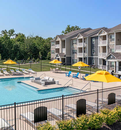A pool surrounded by yellow umbrellas and chairs.