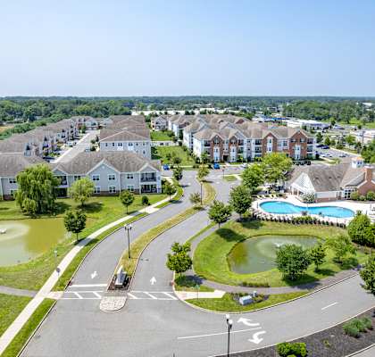 A view of a housing complex with a pool and a roundabout.