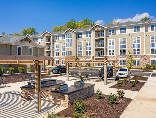 an outdoor patio with a firepit and picnic table at the enclave at woodbridge apartments in