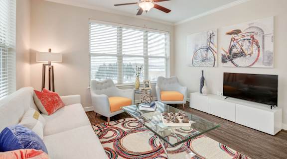 a living room with a couch and a glass coffee table and a television