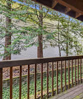 A wooden deck with a sliding door leading to a backyard.