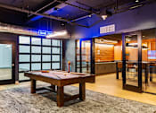 Thumbnail 4 of 4 - A pool table is in the middle of a room with a blue neon sign that says "GAME ON".
