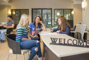 People signing a lease in office lobby with leasing agent sitting at the desk at The Bartram, Gainesville, FL 32608