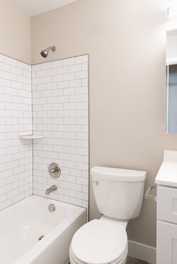 A white bathroom with a toilet, sink, and bathtub.