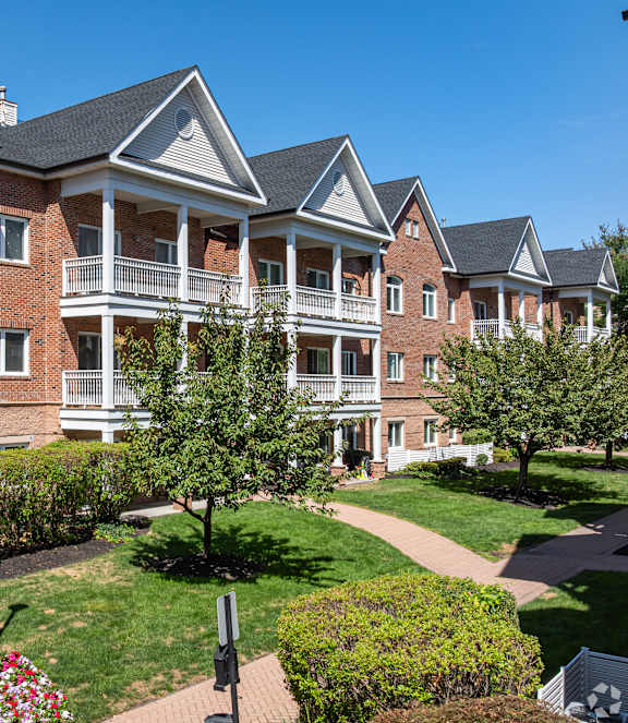 A large red brick building with a white trim and a black roof.