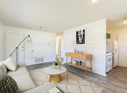 A living room with a couch, a coffee table, and a painting on the wall.