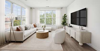 A modern living room with a white sofa, a round coffee table, and a flat-screen TV mounted on the wall at Aspire Apollo, Maryland