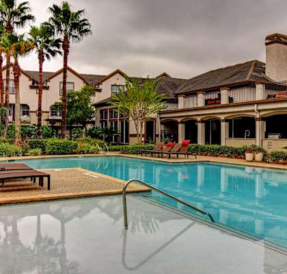 a swimming pool with a building in the background at Stone Creek at Old Farm Apartments, Houston, Texas