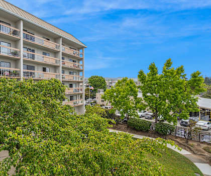 a view of an apartment building with trees in front of it